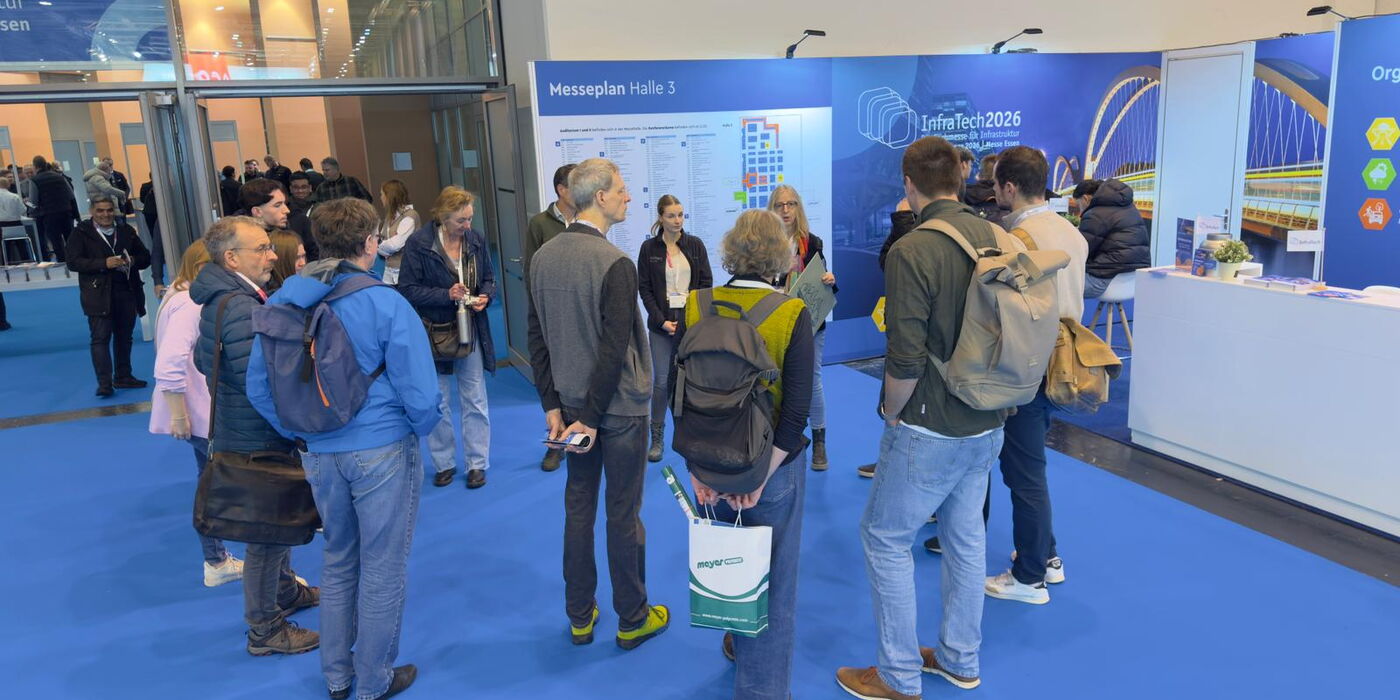 Eine Gruppe aus Menschen, die in einem Kreis stehen und gespannt einer Person zuhören